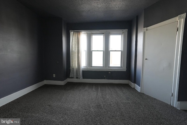 carpeted spare room with a textured ceiling