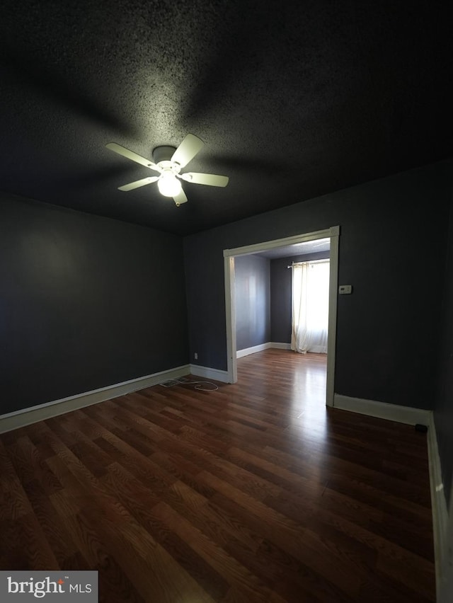 spare room with ceiling fan, dark hardwood / wood-style floors, and a textured ceiling