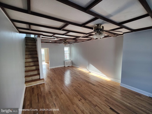 unfurnished living room with beamed ceiling, dark hardwood / wood-style floors, and ceiling fan