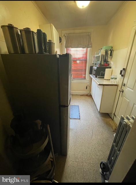 kitchen with cream cabinetry and stainless steel refrigerator