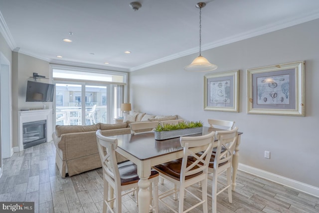 dining area with crown molding and light hardwood / wood-style floors