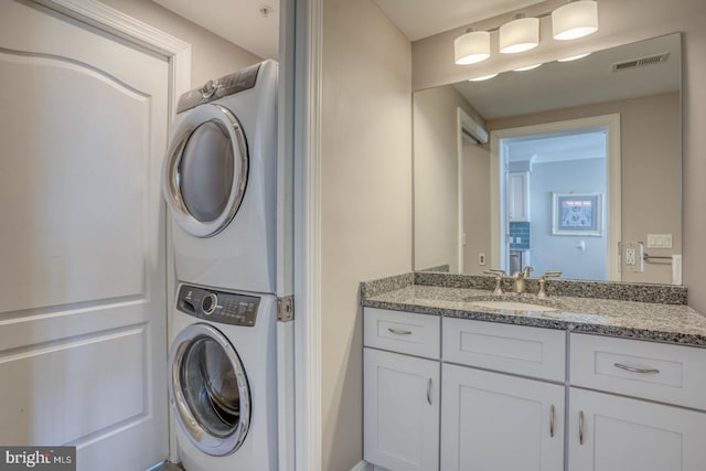 washroom featuring stacked washer / dryer and sink