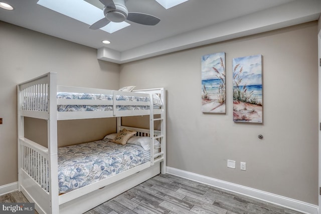 bedroom with wood-type flooring and a skylight