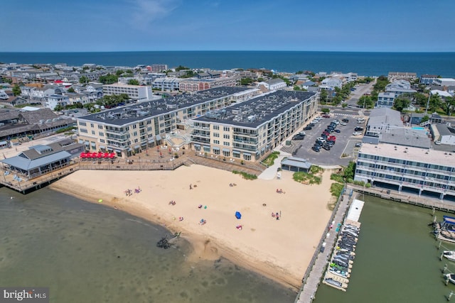 birds eye view of property with a water view and a beach view