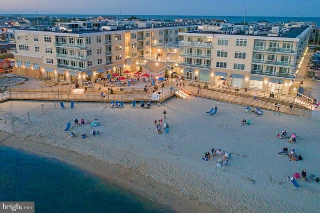 aerial view at dusk with a beach view and a water view