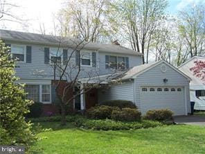 view of property with a garage and a front lawn