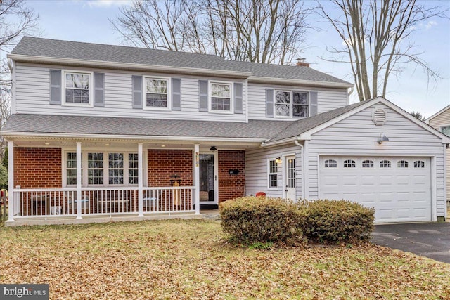 front facade featuring a garage, a front yard, and a porch