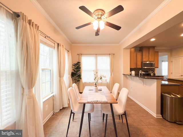 dining room with ornamental molding, a healthy amount of sunlight, sink, and tile patterned floors