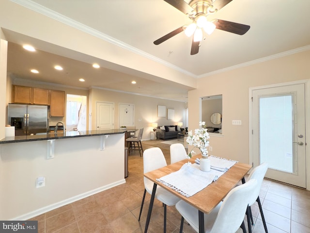 dining space with sink, crown molding, and light tile patterned flooring