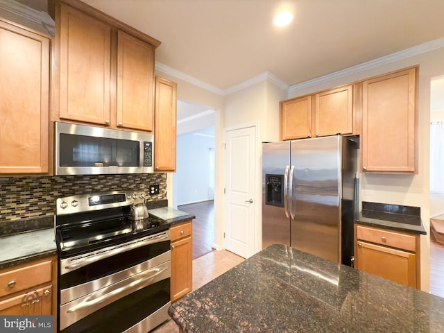 kitchen with dark stone countertops, decorative backsplash, ornamental molding, and stainless steel appliances