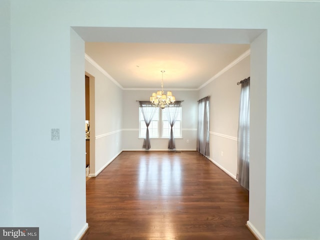 unfurnished dining area with dark hardwood / wood-style flooring, ornamental molding, and an inviting chandelier