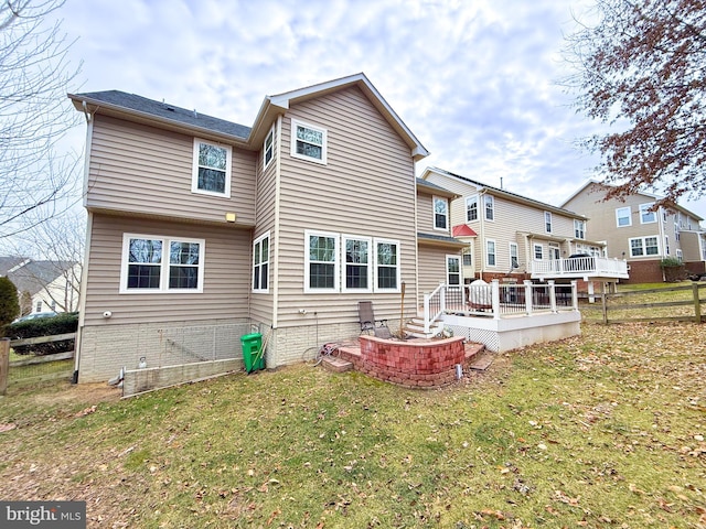 back of property with a wooden deck and a yard