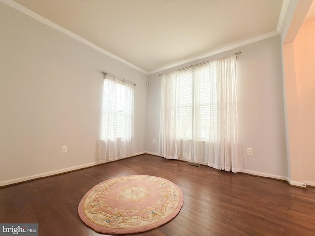 spare room with crown molding and dark wood-type flooring