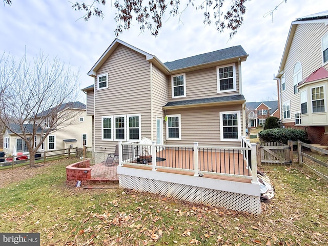 rear view of house with a lawn and a deck