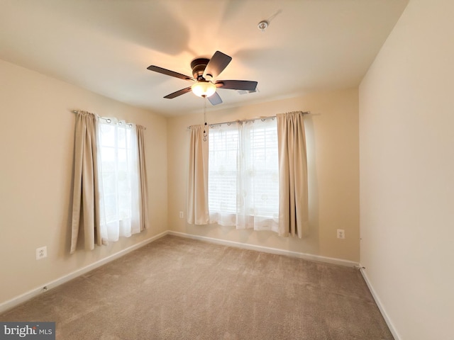 unfurnished room with plenty of natural light, ceiling fan, and carpet