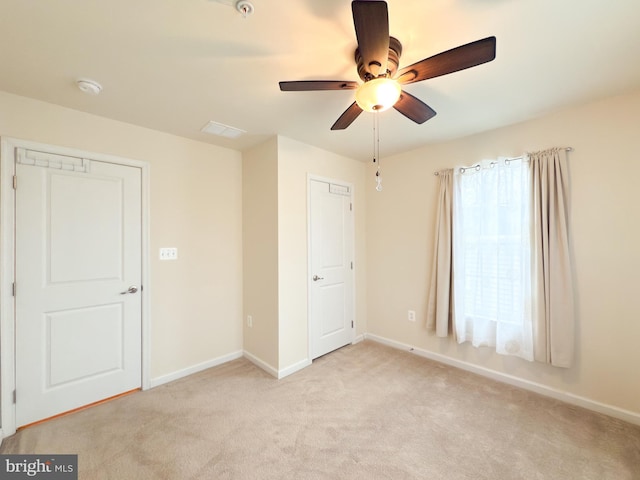 unfurnished bedroom with ceiling fan and light colored carpet