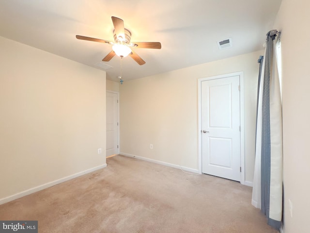 unfurnished room with light colored carpet and ceiling fan