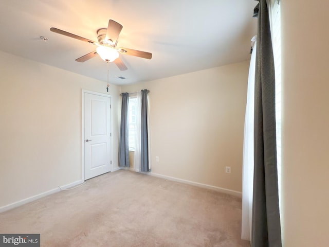 carpeted spare room with ceiling fan