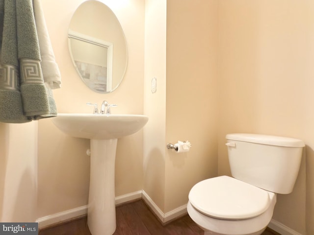 bathroom with hardwood / wood-style floors and toilet