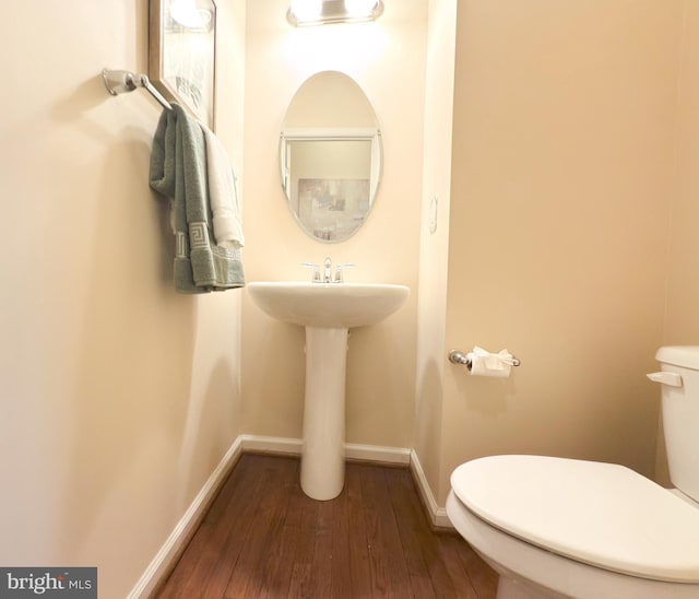 bathroom featuring wood-type flooring and toilet