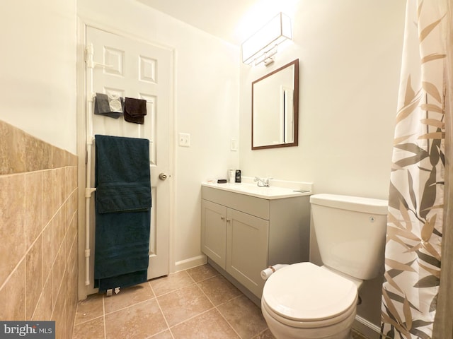 bathroom featuring vanity, tile walls, tile patterned floors, and toilet