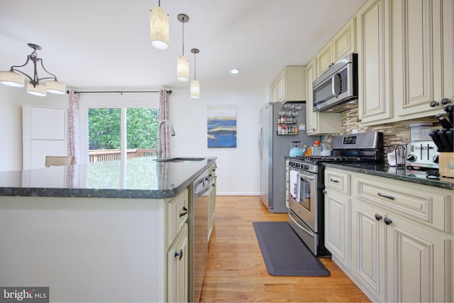 6406 Holyoke Dr, Annandale, VA 22003 - kitchen featuring appliances with stainless steel finishes, cream cabinets, tasteful backsplash, a center island with sink, and a sink