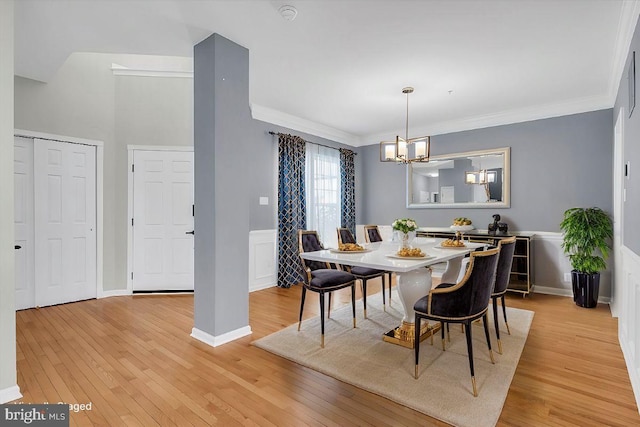 dining area featuring an inviting chandelier, ornamental molding, and light hardwood / wood-style floors