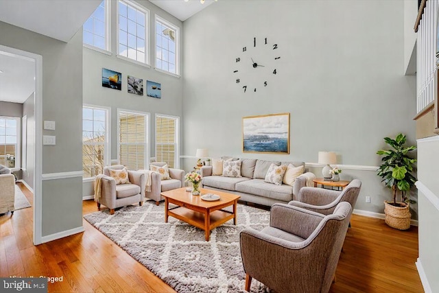 living room featuring wood-type flooring and a high ceiling