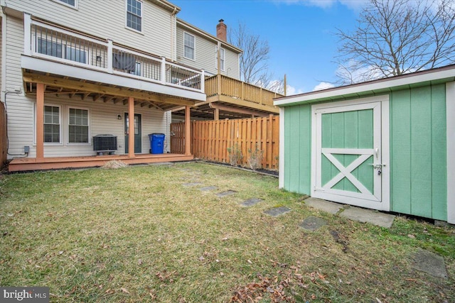 view of yard with central air condition unit, a storage unit, fence, an outdoor structure, and a wooden deck