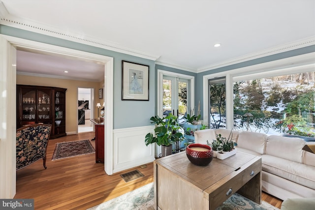 living room featuring crown molding, wood-type flooring, and french doors