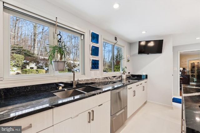 kitchen with white cabinetry, sink, and dark stone counters