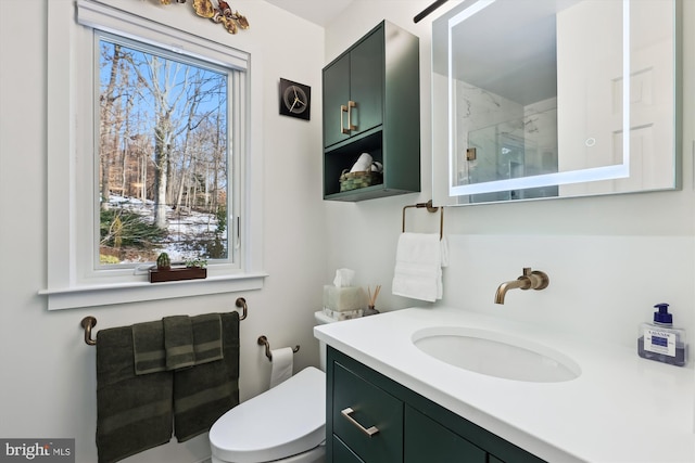 bathroom featuring vanity, walk in shower, and toilet