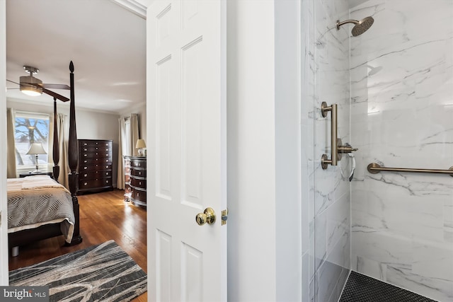 bathroom featuring a tile shower, hardwood / wood-style flooring, crown molding, and ceiling fan