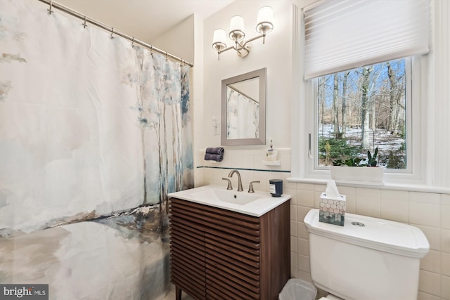 bathroom featuring tile walls, vanity, and toilet