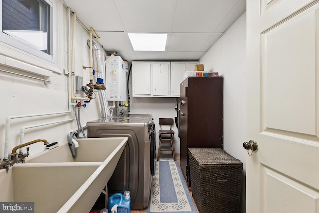 laundry area with sink, cabinets, independent washer and dryer, and tankless water heater