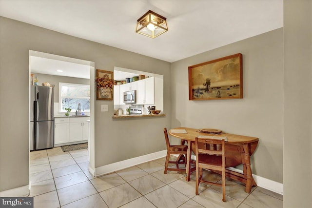 dining room featuring light tile patterned flooring and sink