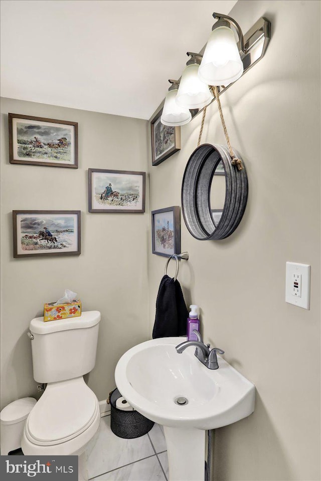 bathroom featuring sink, tile patterned floors, and toilet