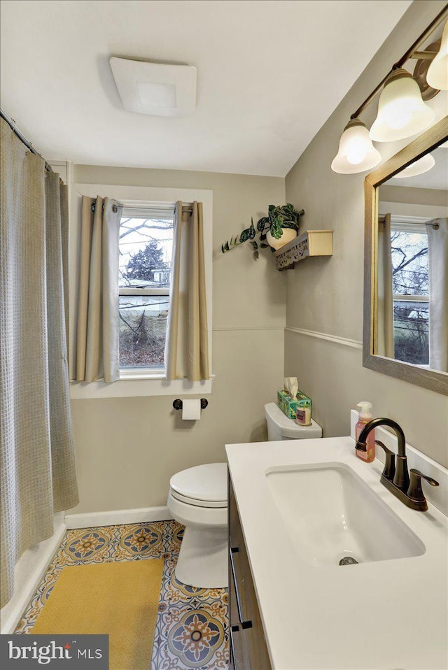 bathroom with tile patterned flooring, vanity, curtained shower, and toilet