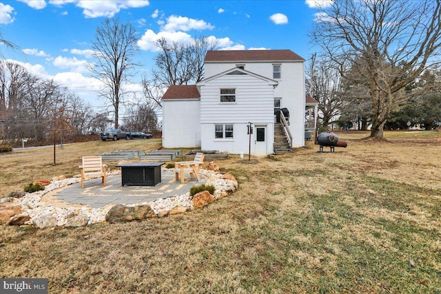 back of house with a yard, a patio area, and an outdoor fire pit