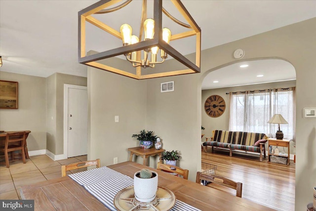 dining room with light tile patterned floors and a chandelier