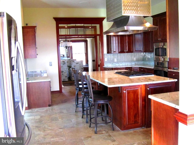 kitchen with tasteful backsplash, island range hood, a center island, stainless steel appliances, and light stone countertops