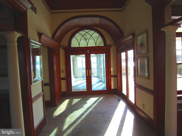 doorway to outside with ornate columns, vaulted ceiling, and french doors