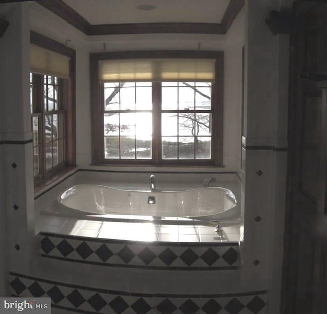 bathroom featuring plenty of natural light and tiled bath