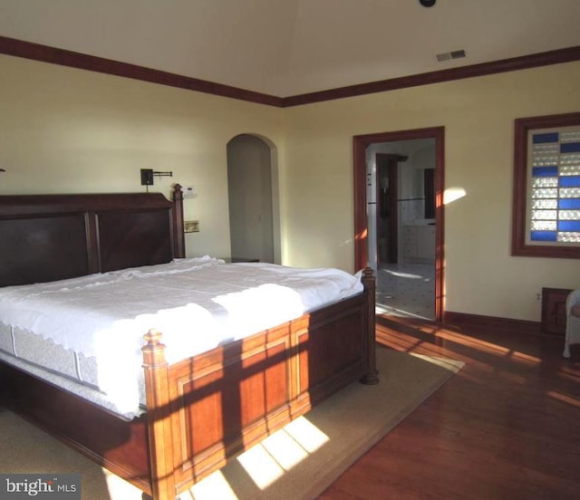 bedroom with ornamental molding and dark hardwood / wood-style flooring