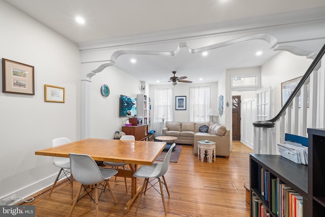 dining space featuring light hardwood / wood-style flooring, ceiling fan, and ornate columns