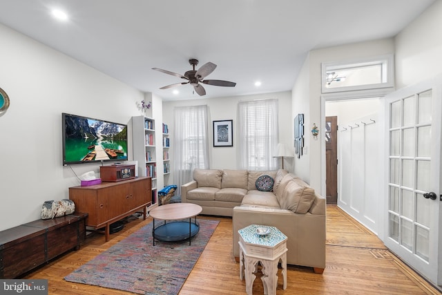 living room with light hardwood / wood-style floors and ceiling fan