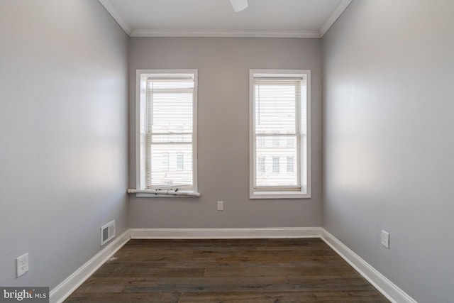 empty room featuring dark hardwood / wood-style flooring, plenty of natural light, and ornamental molding