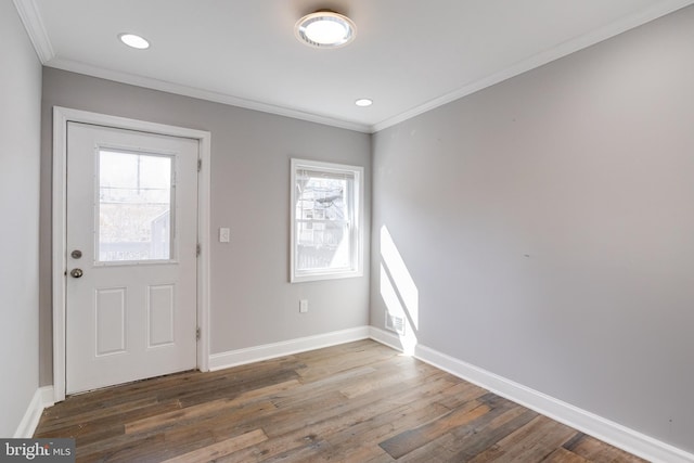 foyer entrance with ornamental molding and dark hardwood / wood-style flooring