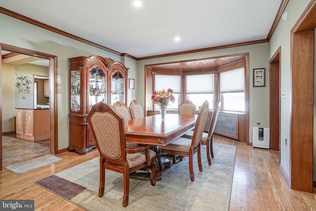 dining room featuring ornamental molding and light wood-type flooring