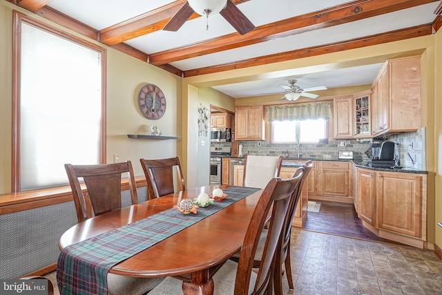 dining space with beamed ceiling, sink, and ceiling fan